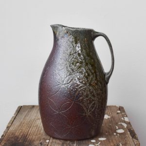 Katriona Drijber a ceramic artist from the Elk Valley, handcrafted ornate pattern and orchid design on pitcher in Fernie, BC at H squared art gallery - salt and soda exhibit