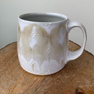 wheel thrown porcelain mug in brown with drippy glaze and decal design by Katy Drijber