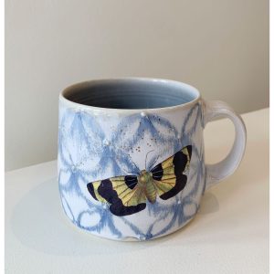 Katriona Drijber's yellow and black moth with gold dots in blue snowflake or floral pattern porcelain mug at h squared gallery in Fernie, BC