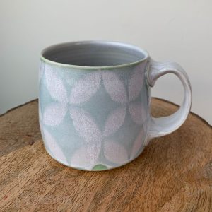 wheel thrown porcelain mug by Alberta potter Katy Drijber snowflake or floral pattern in green