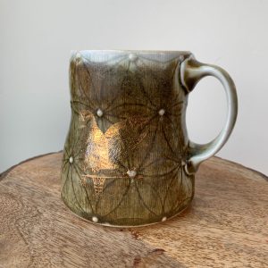 porcelain wheel thrown mug by Katy Drijber with a green glaze, floral decal pattern and two gold foil owls with handle