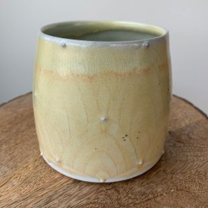 yellow wheel thrown pottery mug with floral design by Katriona Drijber at H Squared in Fernie