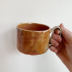 Heather Dynes Smit, hand built potter and wood fired ceramic mug with orange finish